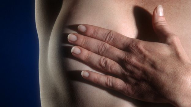 Mujer examinándose el pecho