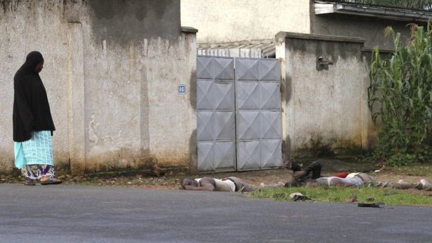 A resident looks at bodies of men killed during gunfire in the Nyakabiga neighbourhood of Burundi's capital Bujumbura