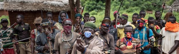 In this photograph taken on August 16, 2017, anti-Balaka combatants patrol in the parish of Gambo, south-eastern Central African Republic. On 13 May 2017, dozens of anti-Balaka fighters stormed the city of Bangassou. They killed dozens of Muslim civilians. Since then, the administration and a large number of residents have fled the city.