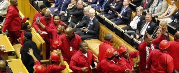 Julius Malema, center, leader of the Economic Freedom Fighters political party leaves the inside of parliament with his members as President Jacob Zuma attempts to give his state of the nation address in Cape Town, South Africa, Thursday, Feb. 11, 2016.
