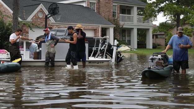 People use boats to help bring items out of homes on September 3, 2017 in Houston, Texas.