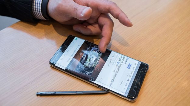 A Samsung customer browses a web page showing a fire-damaged Samsung Note 7 mobile phone, on a similar device, at a Samsung store in a mall beneath the company's headquarters in the Gangnam district of Seoul on October 12, 2016