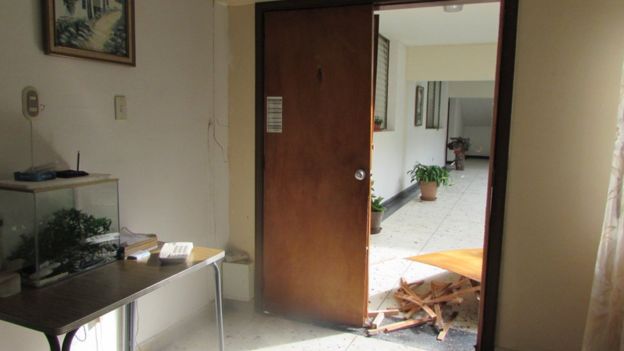 A door lies in pieces at the entrance to a room at the building housing Christian Brothers