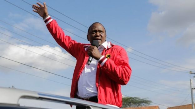 Kenyan President Uhuru Kenyatta speaks from the back of a vehicle