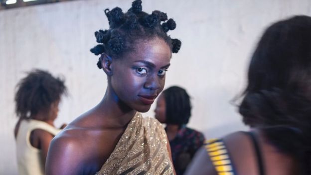 A model gets her outfit fitted prior to the heading out on the catwalk at the Accra Fashion Week in Ghana on October 7, 2016