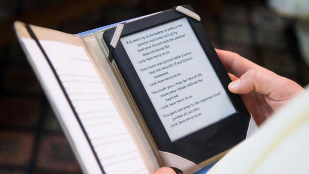 Una persona leyendo la Biblia en un libro electrónico
