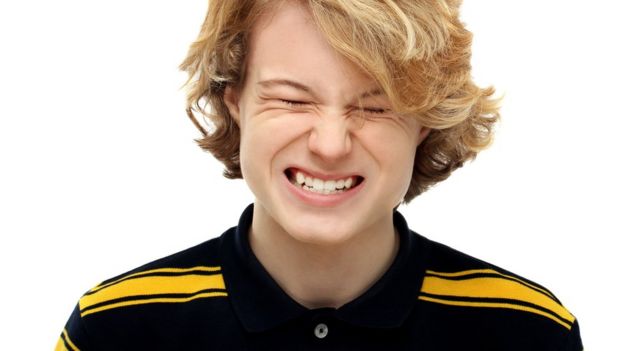Adolescente apretando los dientes