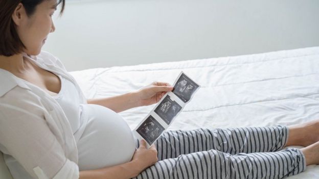 امرأة حامل تنظر إلى صورة