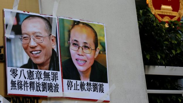 Photos of Chinese Nobel rights activist Liu Xiaobo (L) and wife Liu Xia are left by protesters outside China