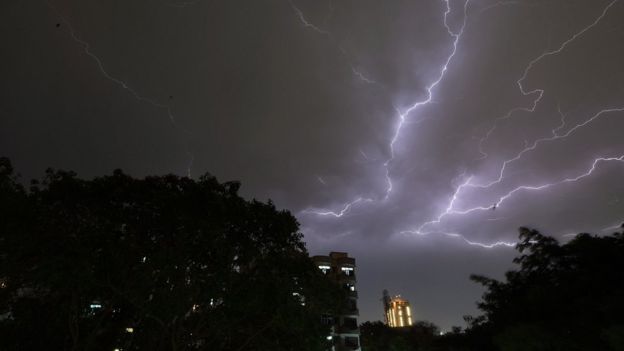 Lightning strikes over residential apartments during a thunderstorm on the outskirts of the Indian capital Delhi on 2 May 2018