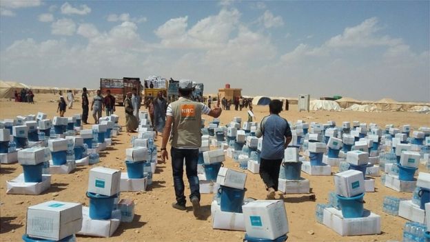 Members of the Norwegian Refugee Council hand out emergency kits to displaced people in western Iraq