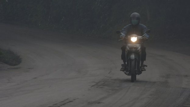 A motorist rides his motorbike during a shower of ash and rain from Mount Agung volcano during an eruption in Bebandem Village, Karangasem, Bali, Indonesia 26 November 2017, in this photo taken by Antara Foto.