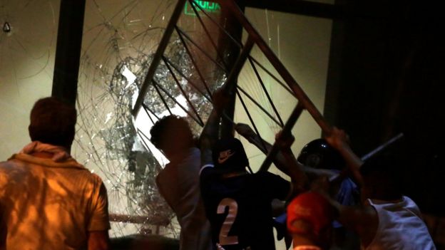 Manifestantes intentan romper una ventana del Congreso.