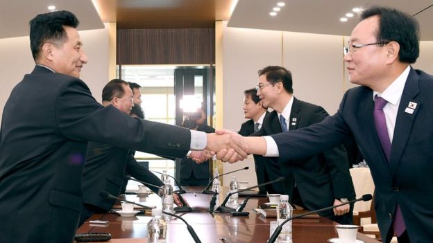 Las delegaciones de Corea del Norte y del Sur se estrechan la mano, tras conversaciones de distensión.