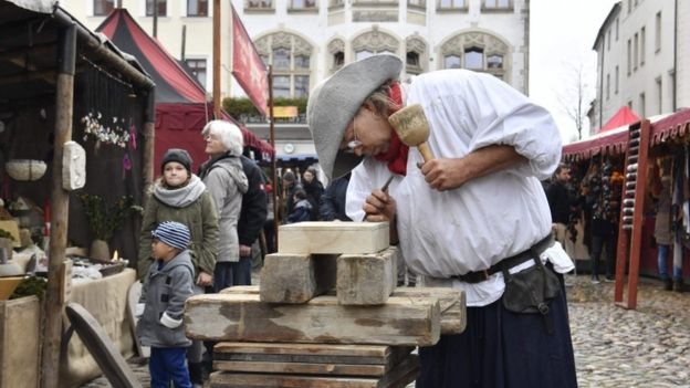 A traditional wood cutter engraves wood in the main square in Wittenberg, eastern Germany, where celebrations take place on the occasion of the 500th anniversary of the Reformation on October 31, 2017