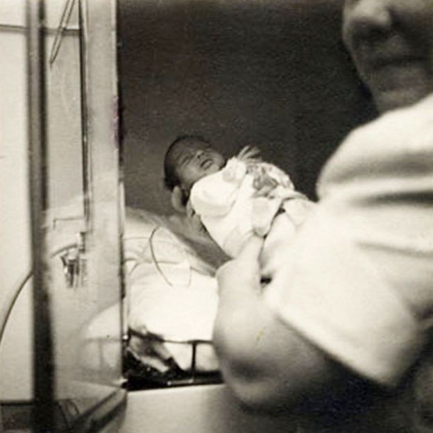 Colocando un bebé en una de las incubadoras.