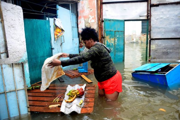 A woman tries to rescue some food from her flooded house in downtown Havana, Cuba, 10 September