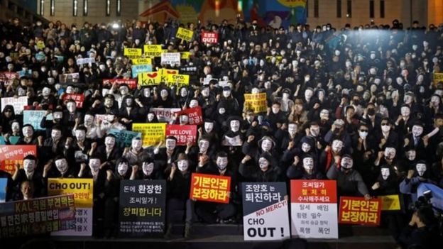 Các nhân viên biểu tình phản đối gia đình Cho đeo mặt nạ để giấu danh tính