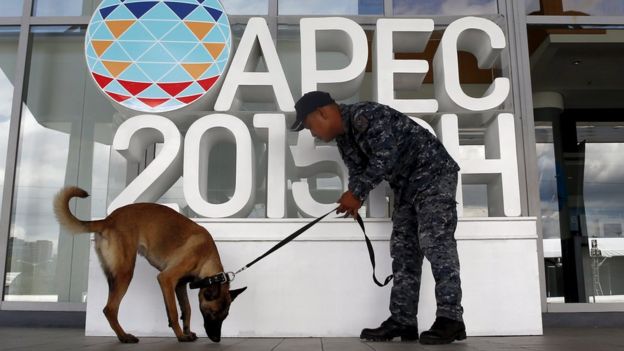 A soldier uses a canine to check the surroundings of the International Media Center during the security preparation for the Apec summit in Manila on 12 November, 2015