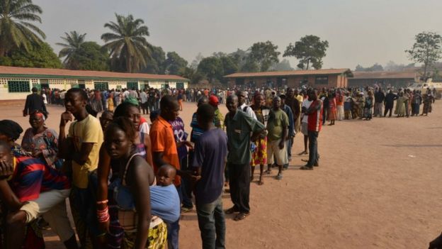 People queue outside a polling station on December 30, 2015 as they go to the polls to take part in the country's presidential and legislative in the ¨PK5 district of the capital Bangui