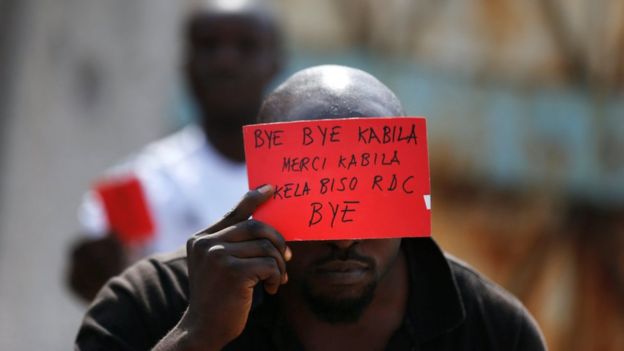 Protester holding anti-Kabila banner