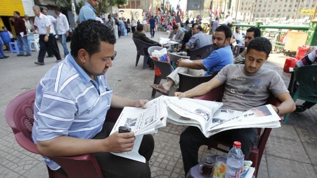 مصريون يطالعون الصحف في القاهرة