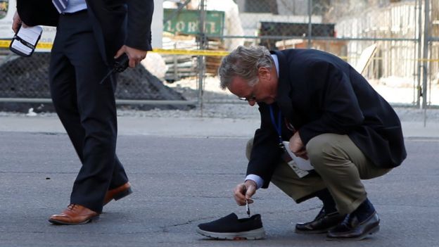 Un investigador toca con un bolígrafo un zapato abandonado en la escena del suceso.