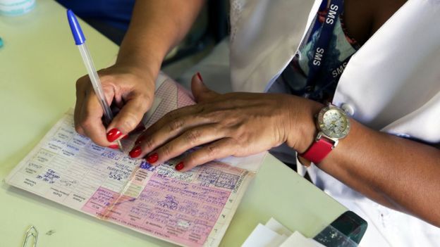 Mulher preenche carteira de vacinação