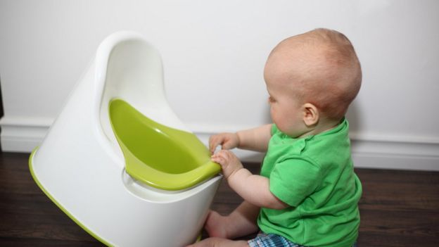 Bebé jugando con un inodoro