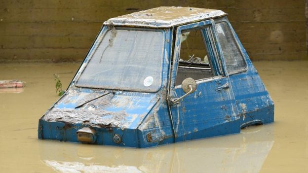 A picture shows a partially submerged car in the Livorno area, flooded after heavy rain, on September 10, 2017.