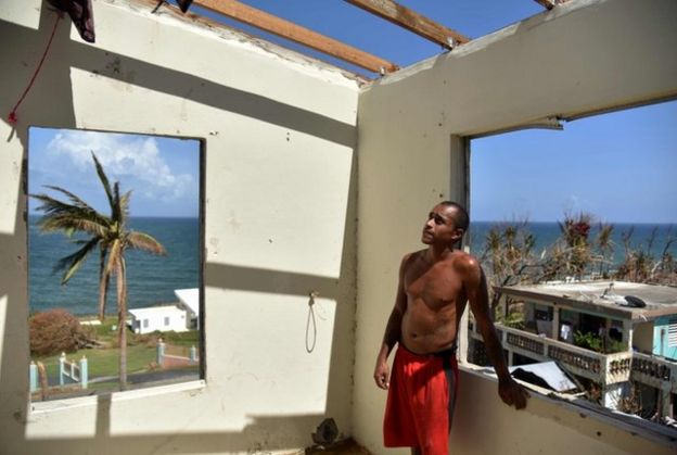 Un joven mira su casa destruida por el huracán.