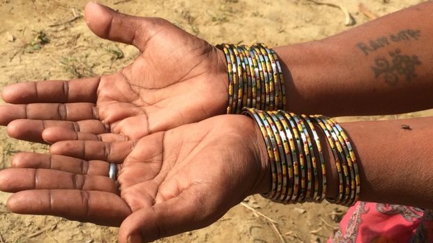 An Indian woman shows a tattoo of her husband's name