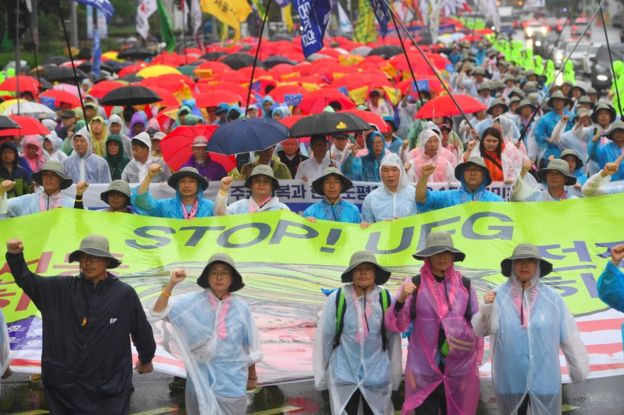 South Korean protesters hold a banner reading