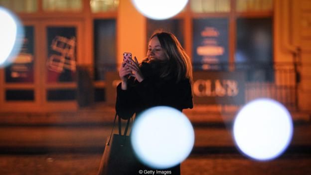 Una mujer con su móvil en la calle.