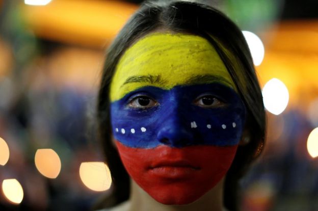 Manifestante con los colores venezolanos pintados en la cara