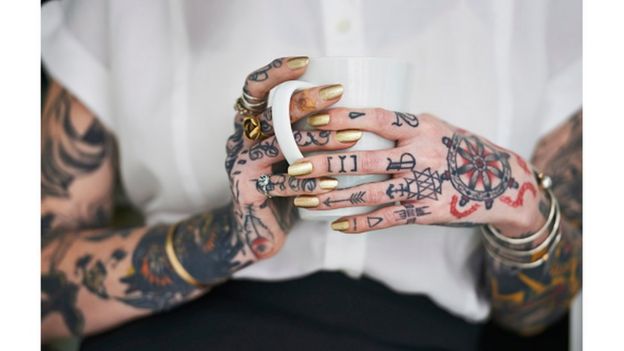 Mulher com braços e mãos tatuadas
