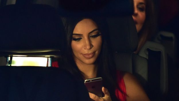 Kim Kardashian con su celular en un auto