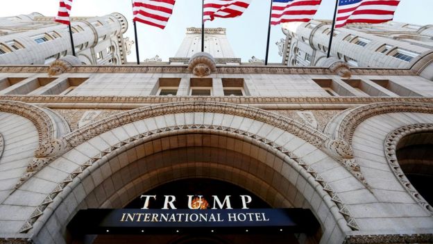 Banderas flamean sobre la entrada al nuevo hotel internacional de Trump en su día de la inauguración en Washington D.C.