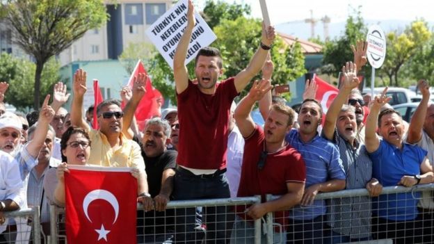 People protest against arrested soldiers who allegedly participated in last year's attempted coup as they arrive for their trial (01 August 2017)