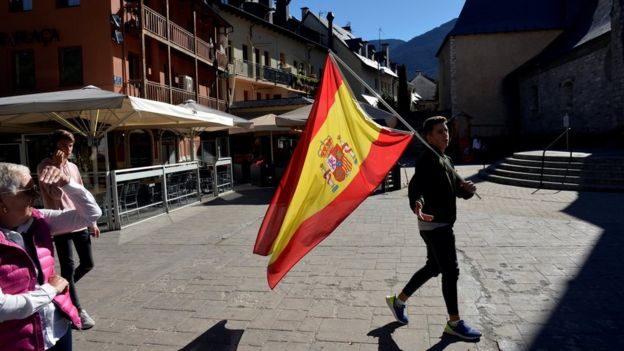 Un joven sostiene una bandera de España
