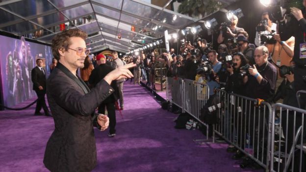 Robert Downey Jr stands in front of photographers on the red carpet at the Avengers: Infinity War premiere in Los Angeles