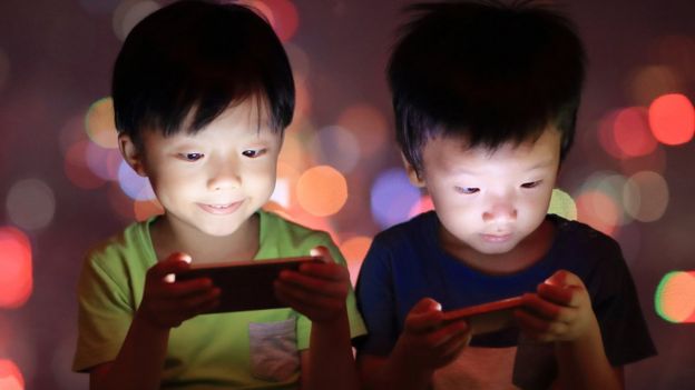 Niños jugando con celular