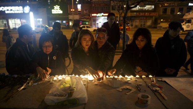 People lay candles and leave messages at a memorial for victims on Yonge Street, Toronto, on April 23, 2018