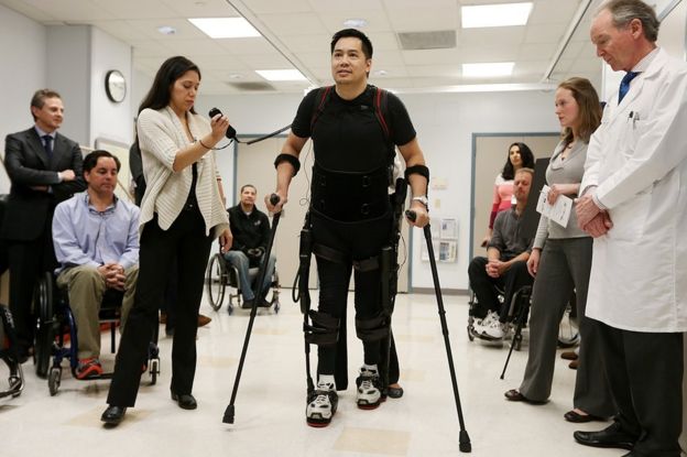 un hombre camina con un exoesqueleto.