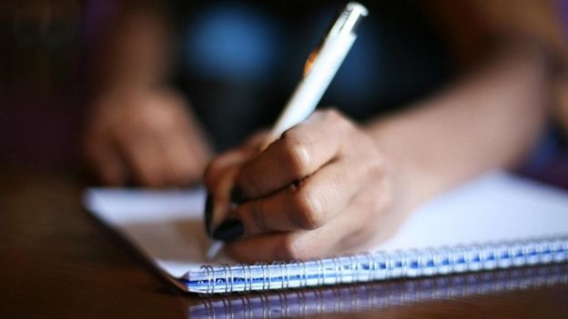 شابة تكتب في كراسة