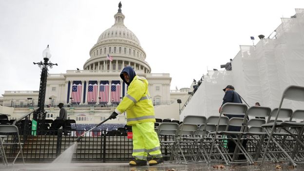Un hombre limpia el piso frente al Capitolio de Washington DC