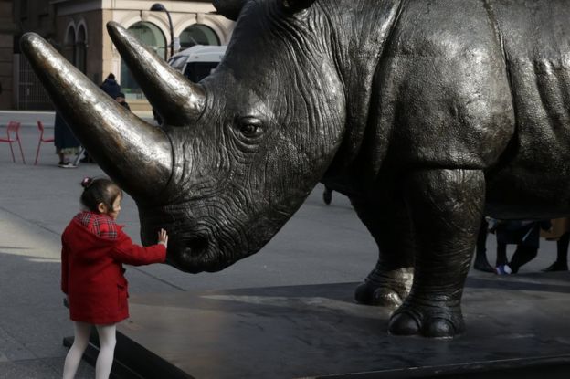 A young child touches The Last Three, the world's largest rhino sculpture, which is on display by artists Gillie and Marc Art at Astor Place in New York, New York, USA, 15 March 2018