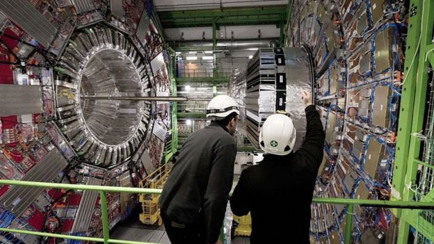 Dos personas observando el Gran Colisionador de Hadrones.