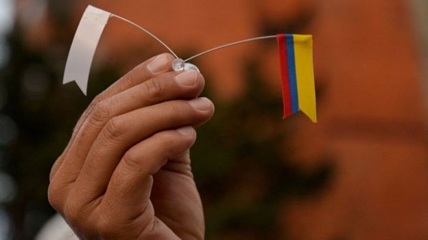 Pequeñas banderitas: una blanca y una de Colombia.