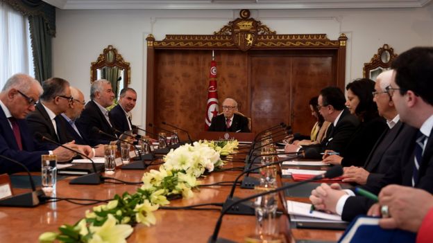 President surrounded by politicians unionists and employers at a long table